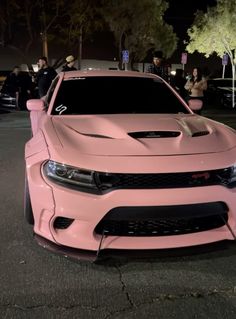 a pink car parked on the street at night