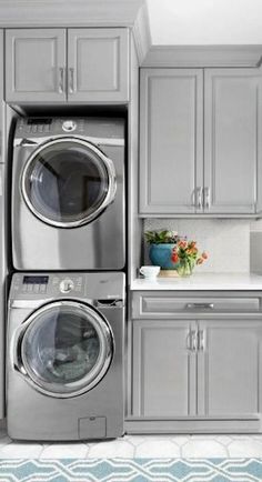 a laundry room with gray cabinets and washer and dryer