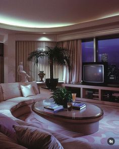 a living room filled with furniture and a flat screen tv sitting on top of a wooden table