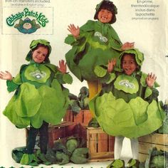 two children in cabbage costumes standing next to each other with their hands up and smiling