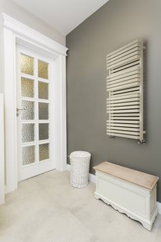 a white bench sitting next to a wall mounted radiator