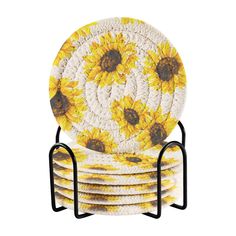 a stack of yellow and white plates on a black metal stand with sunflowers