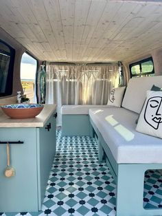 the inside of a camper with blue and white flooring