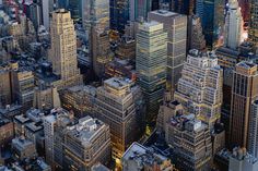 an aerial view of skyscrapers in new york city at night with the lights on