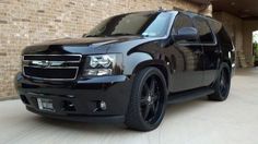 a black suv parked in front of a brick building