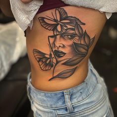 a woman's stomach with a butterfly tattoo on her belly and the image of a woman's face