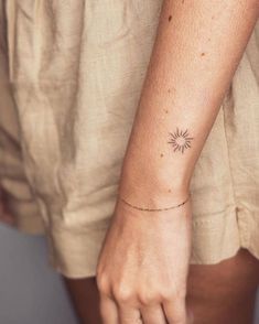 a woman's arm with a small star tattoo on it