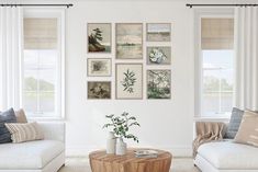 a living room filled with white furniture and pictures on the wall above it's coffee table