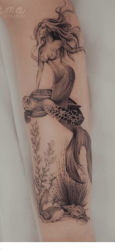 a woman's arm with a tattoo on it and an image of a mermaid