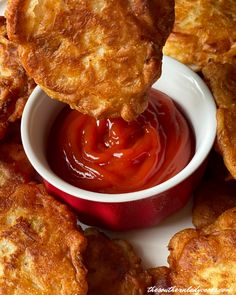 some fried food is being dipped with ketchup