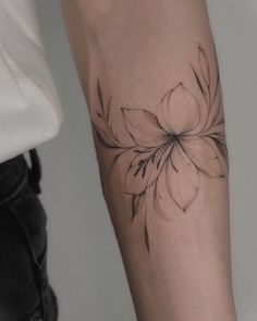 a woman's arm with a flower tattoo on it