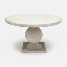 a white marble table with a pedestal base