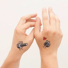 two people with matching tattoos on their hands