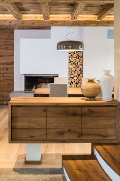 a living room with wood floors and white walls, including a large wooden table in the center