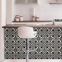 a black and white tile backsplash in a kitchen with bar stools next to it