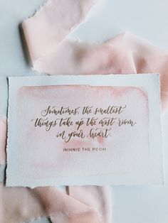 a piece of paper with a quote on it sitting on top of some pink tissue