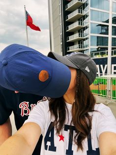 a man and woman kissing in front of a baseball stadium