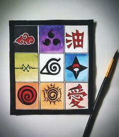 a pen is sitting on top of a piece of paper that has various symbols painted on it