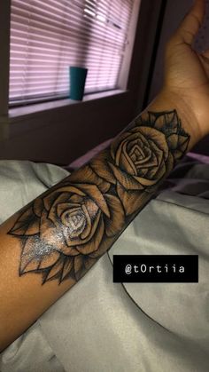 a woman's arm with a rose tattoo on it and the word love written in black ink