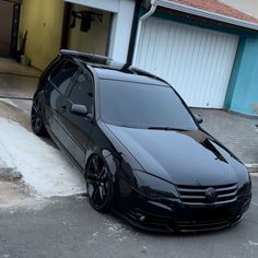 a black car parked in front of a garage