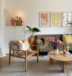 a living room filled with furniture and flowers on top of a rug in front of a window