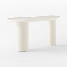 a white oval table sitting on top of a white floor