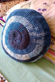 a blue and white basket sitting on top of a bed