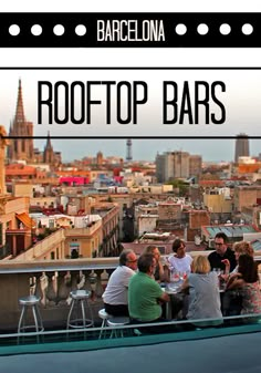 people sitting at a table on top of a roof with the city in the background