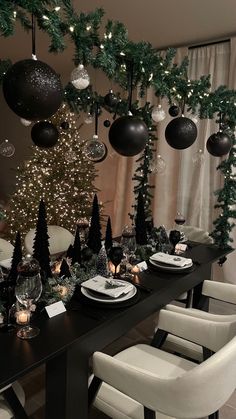 a dining room table decorated for christmas with black and white decorations