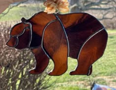 a stained glass bear ornament hanging from a tree