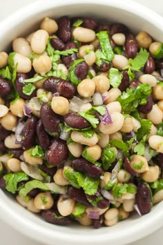 a white bowl filled with beans and greens