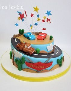 a birthday cake decorated with cars and stars