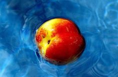 an apple is floating in the blue water