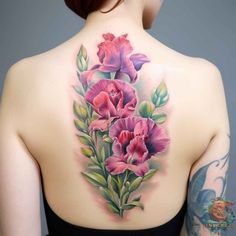 the back of a woman's shoulder with pink flowers on her left and green leaves