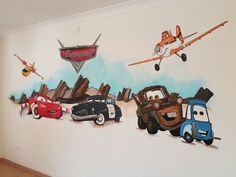 the wall has cars painted on it and planes in the sky above them, as well as an airplane