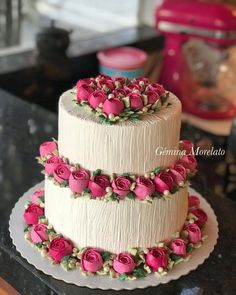 a three tiered cake with pink roses on it