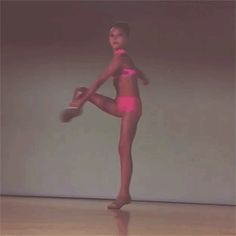 a young woman in pink is dancing on the floor