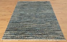 a blue rug with fringes on top of a wooden floor in an empty room