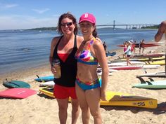 two women in bathing suits standing on the beach