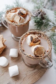 two cups filled with hot chocolate and marshmallows