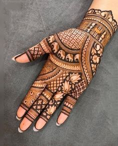 the hand is decorated with henna designs on it's fingers and hands, which are