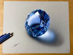 a blue diamond sitting on top of a piece of paper next to two pencils