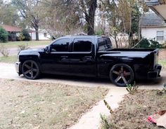 a black truck parked in front of a house