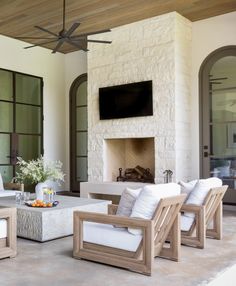 a living room filled with furniture and a flat screen tv mounted on the wall above a fireplace