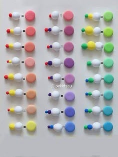 several different colored buttons on a white surface