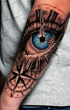 a man's arm with an eye and compass tattoo on the left side of his arm