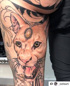 a woman's leg with tattoos on it and a lion head in the middle