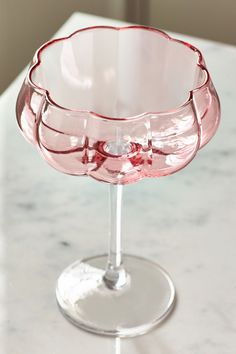 a pink glass sitting on top of a white counter