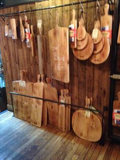 several wooden cutting boards hanging on a wall