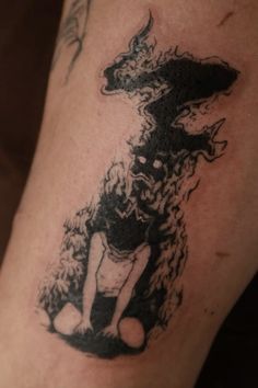 a black and white photo of a person with a dog tattoo on his leg,